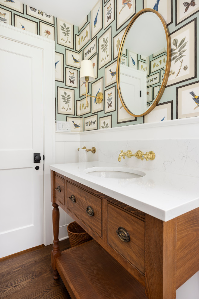 Example of a small classic medium tone wood floor and wallpaper powder room design in Portland with multicolored walls, an undermount sink, quartz countertops and white countertops