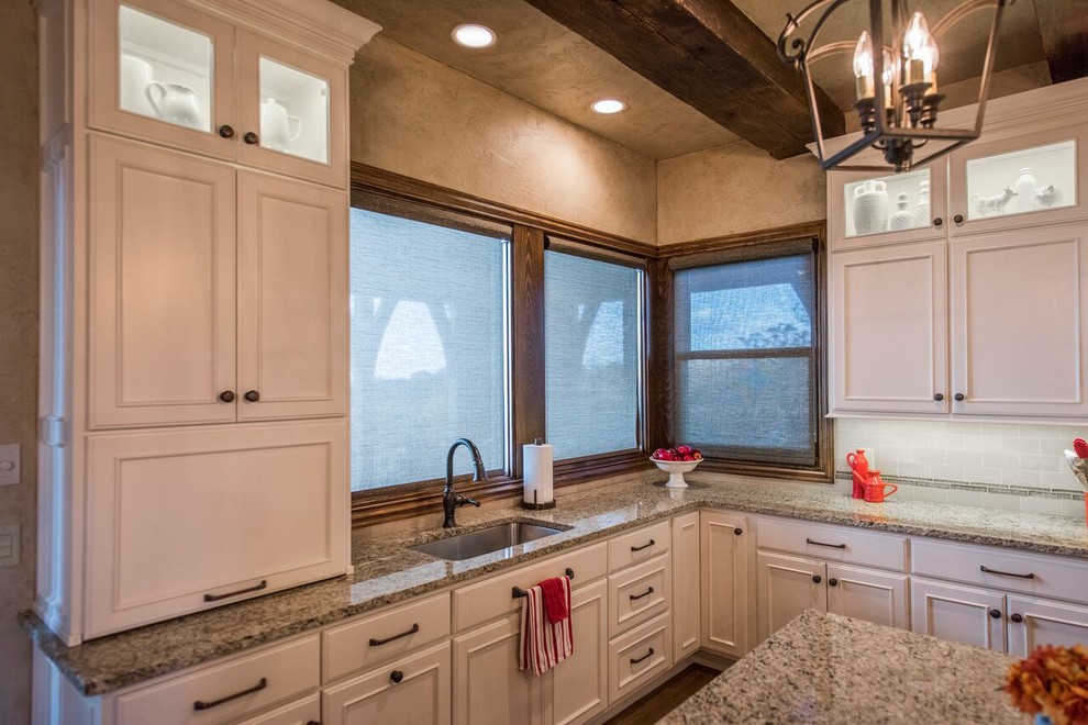 Huge mountain style u-shaped dark wood floor open concept kitchen photo with an undermount sink, beaded inset cabinets, white cabinets, granite countertops, white backsplash, stainless steel appliances and an island