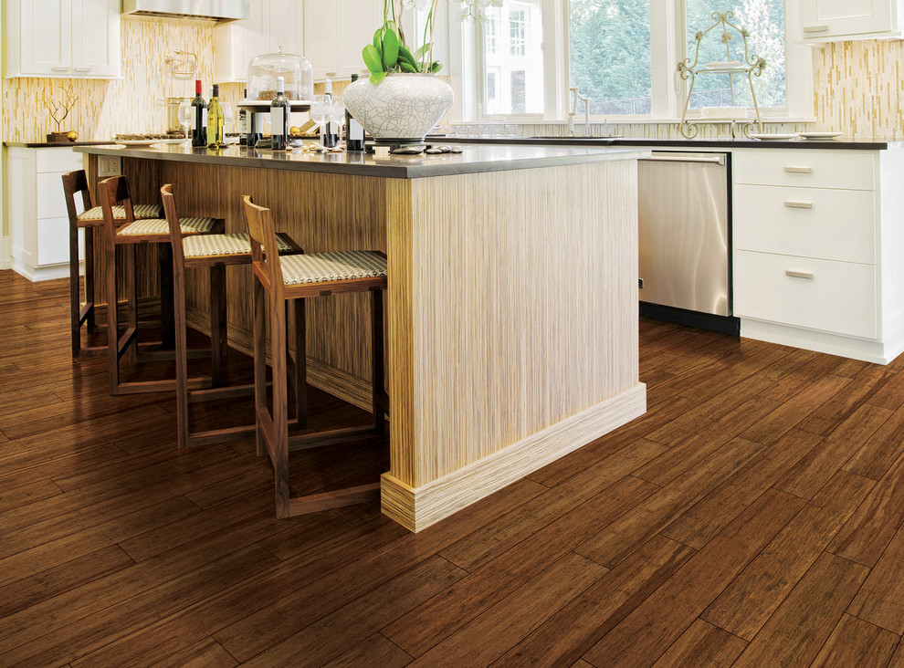 Example of a transitional u-shaped light wood floor and beige floor enclosed kitchen design in Orlando with an undermount sink, flat-panel cabinets, dark wood cabinets, granite countertops, white backsplash, subway tile backsplash, stainless steel appliances and an island