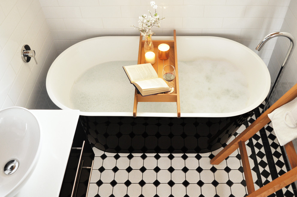 This is an example of a mid-sized traditional master bathroom in Melbourne with a vessel sink, a freestanding tub, white walls, porcelain floors, black cabinets, black and white tile, porcelain tile and quartzite benchtops.