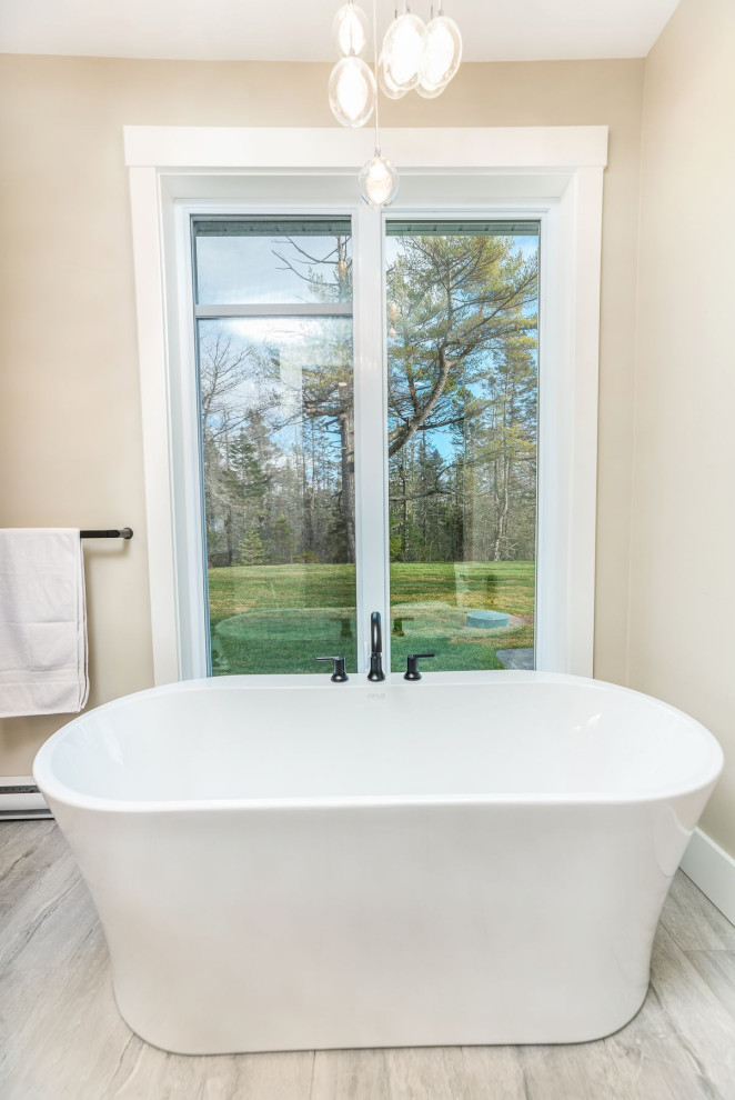 Example of a large transitional master gray tile and ceramic tile ceramic tile and gray floor freestanding bathtub design with a two-piece toilet, beige walls and a hinged shower door