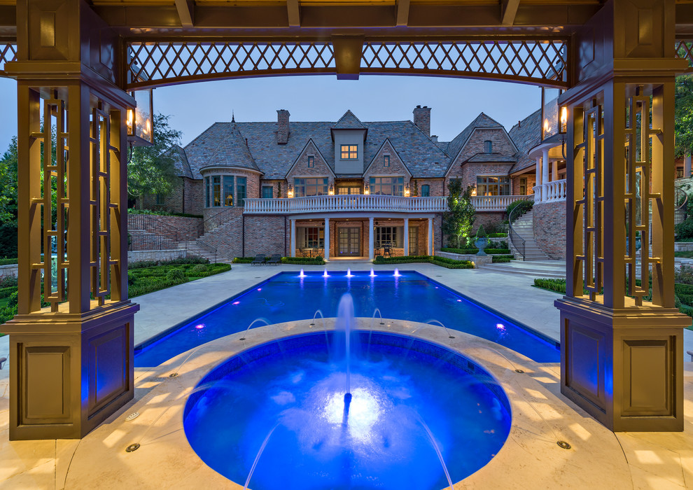 Design ideas for a large traditional rectangular pool in Dallas with a water feature.