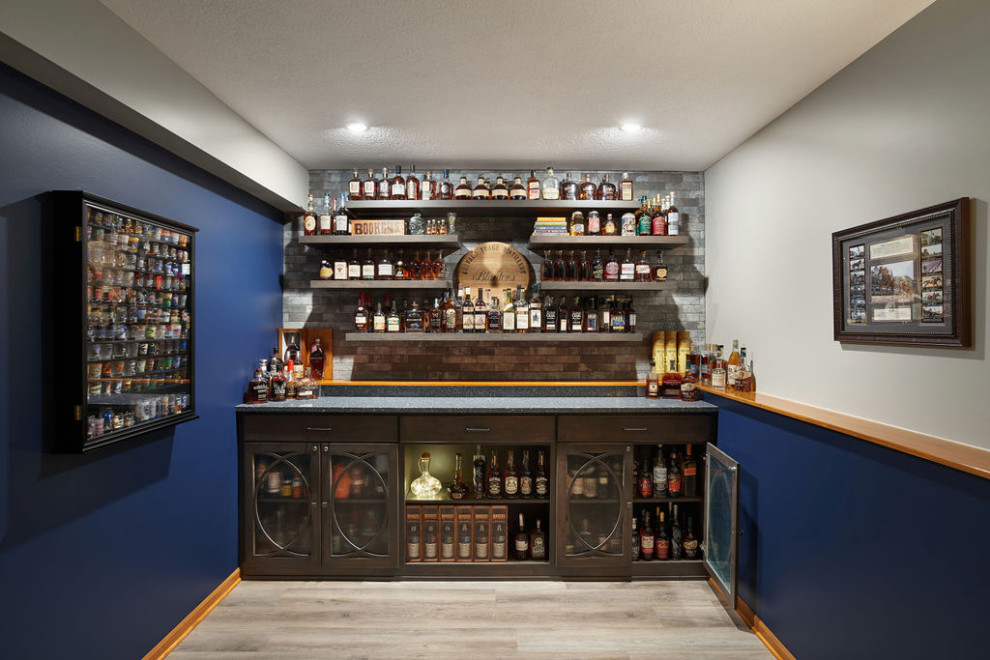 Inspiration for a small classic single-wall dry bar in Columbus with no sink, glass-front cabinets, medium wood cabinets, engineered stone countertops, multi-coloured splashback, brick splashback, vinyl flooring, grey floors and blue worktops.
