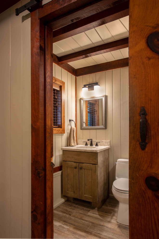 This is an example of a mid-sized country 3/4 bathroom in Other with distressed cabinets, a one-piece toilet, porcelain floors, an undermount sink, engineered quartz benchtops, multi-coloured floor, a shower curtain, a single vanity, a freestanding vanity, exposed beam and panelled walls.