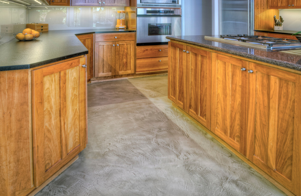 Transitional concrete floor kitchen photo with medium tone wood cabinets, stainless steel appliances and an island
