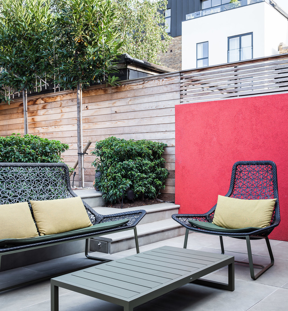 Mid-sized contemporary backyard deck in London with no cover.