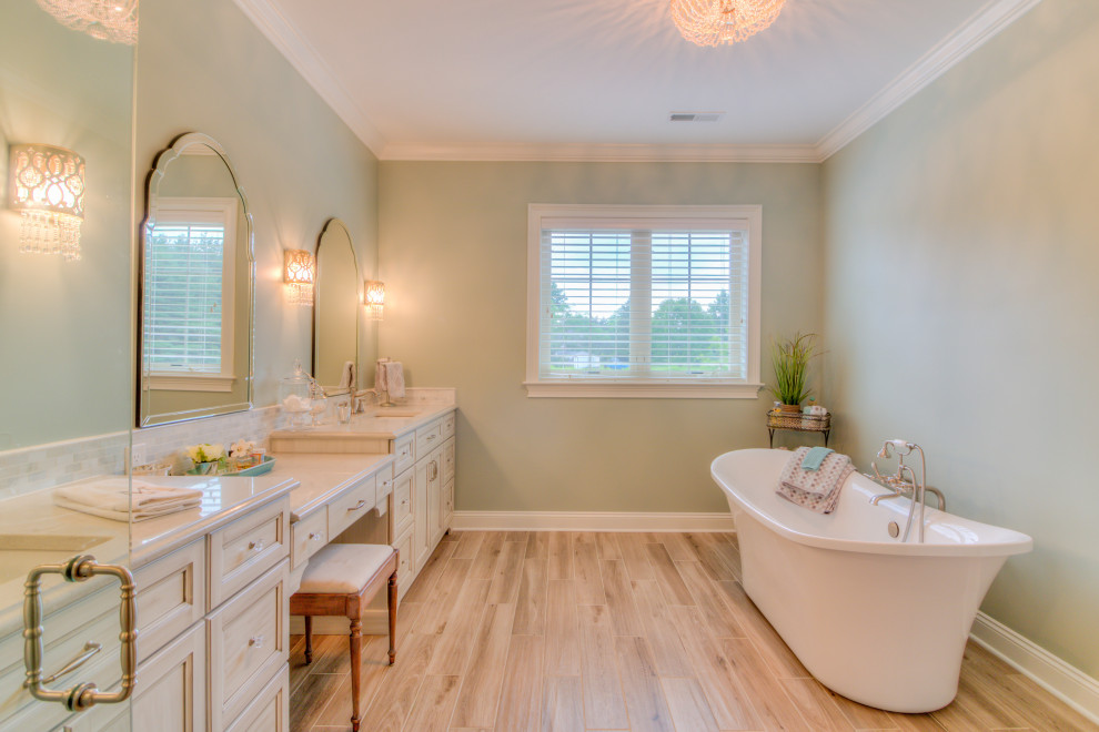 Inspiration for a large master bathroom in Cleveland with beaded inset cabinets, beige cabinets, a freestanding tub, grey walls, vinyl floors, an undermount sink, engineered quartz benchtops, beige floor and beige benchtops.