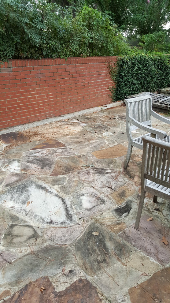 Inspiration for a mid-sized traditional backyard patio in Atlanta with natural stone pavers and no cover.