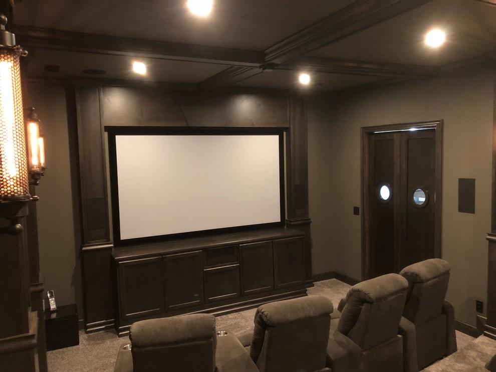 Design ideas for a mid-sized industrial enclosed home theatre in Other with grey walls, carpet, a projector screen and grey floor.