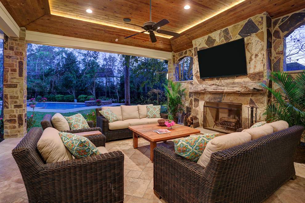 This is an example of a mid-sized country backyard patio in Houston with an outdoor kitchen, tile and a roof extension.