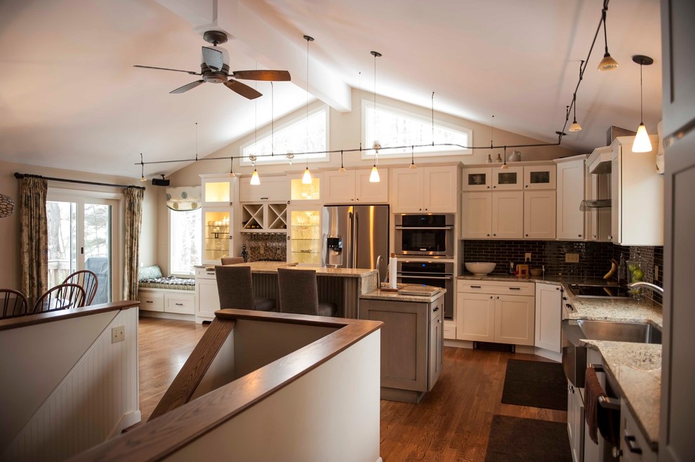 Eat-in kitchen - mid-sized transitional single-wall medium tone wood floor eat-in kitchen idea in Boston with a single-bowl sink, recessed-panel cabinets, white cabinets, granite countertops, black backsplash, stainless steel appliances and an island