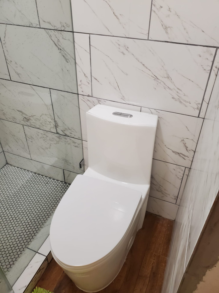 Modern inredning av ett mellanstort badrum med dusch, med en dusch i en alkov, en toalettstol med hel cisternkåpa, vit kakel, vita väggar, mellanmörkt trägolv, brunt golv, dusch med gångjärnsdörr och porslinskakel