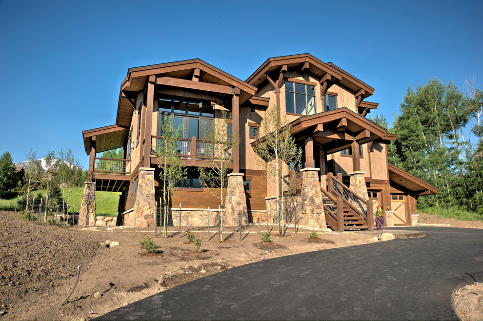 Inspiration for an expansive contemporary two-storey brown exterior in Denver with wood siding.