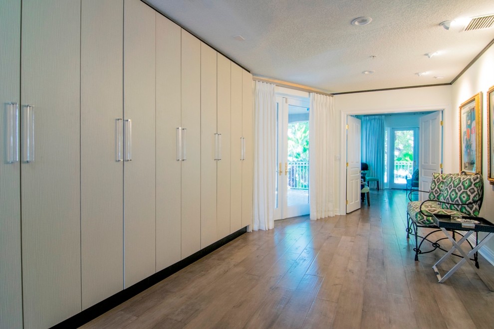 Inspiration for a large contemporary hallway in Tampa with white walls and light hardwood floors.