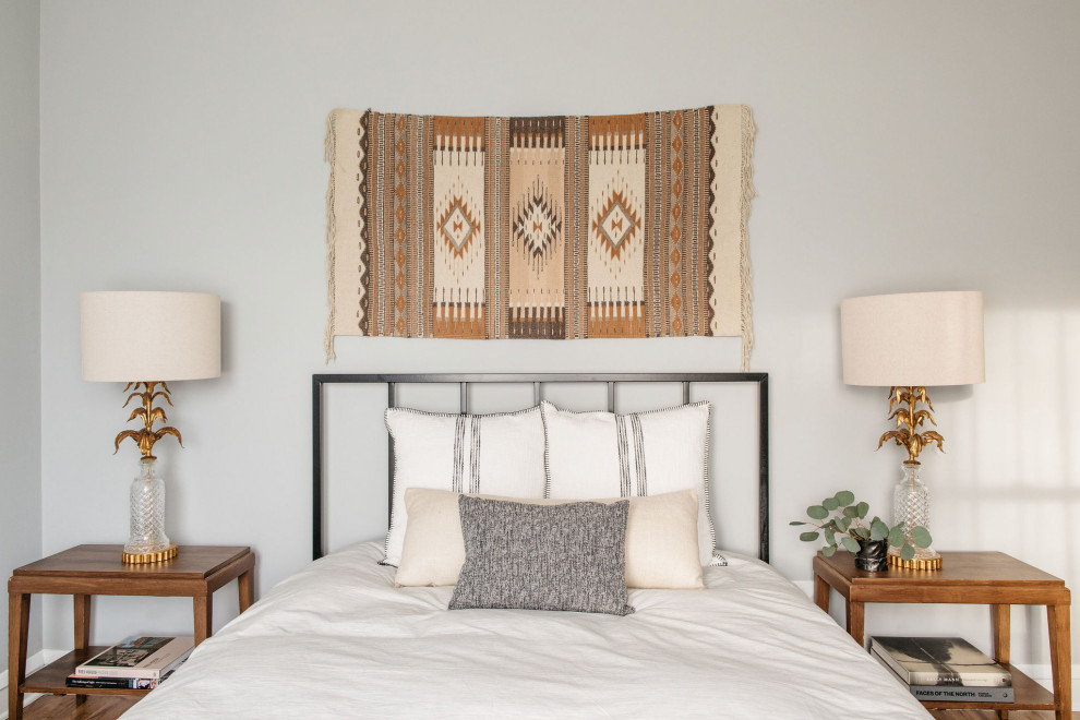 Modelo de dormitorio principal tradicional renovado pequeño con paredes blancas, suelo de madera en tonos medios y suelo marrón