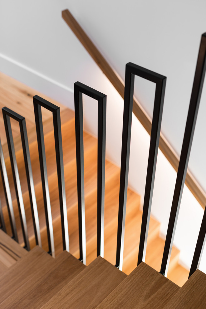 Diseño de escalera en U contemporánea de tamaño medio con escalones de madera, contrahuellas de madera y barandilla de madera