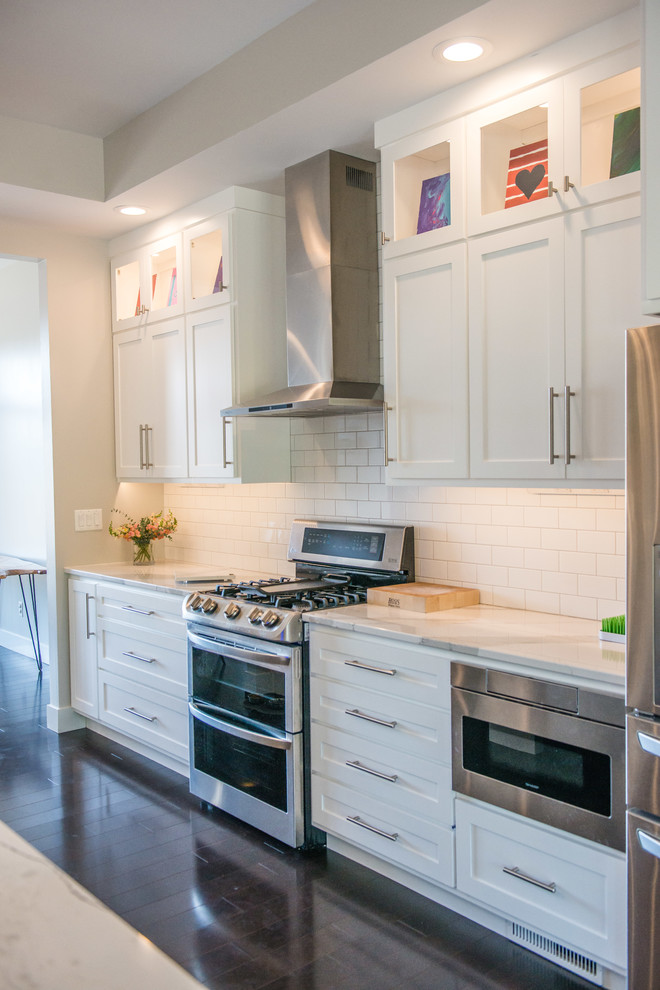 Open concept kitchen - huge transitional l-shaped dark wood floor and brown floor open concept kitchen idea in Chicago with a double-bowl sink, shaker cabinets, white cabinets, quartz countertops, white backsplash, ceramic backsplash, stainless steel appliances and an island
