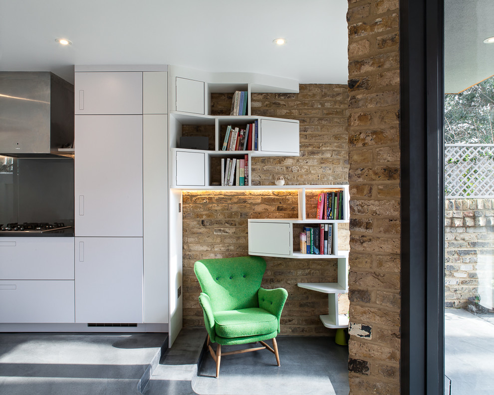 Design ideas for a large contemporary single-wall open plan kitchen in London with an integrated sink, flat-panel cabinets, white cabinets, solid surface benchtops, grey splashback, panelled appliances, concrete floors, grey floor and grey benchtop.