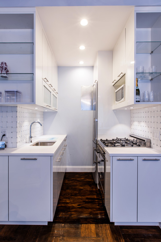Design ideas for a small contemporary galley eat-in kitchen in New York with an undermount sink, flat-panel cabinets, white cabinets, quartz benchtops, white splashback, mosaic tile splashback, stainless steel appliances and dark hardwood floors.