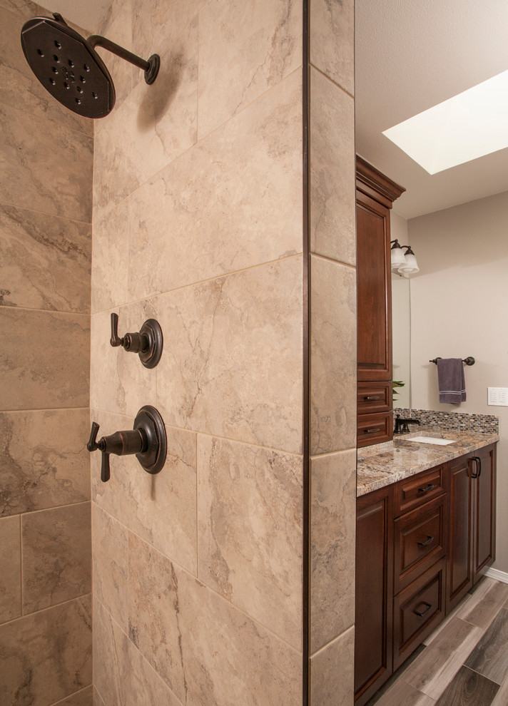 Mid-sized traditional master bathroom in Seattle with raised-panel cabinets, medium wood cabinets, a curbless shower, a two-piece toilet, beige tile, porcelain tile, beige walls, porcelain floors, an undermount sink and granite benchtops.