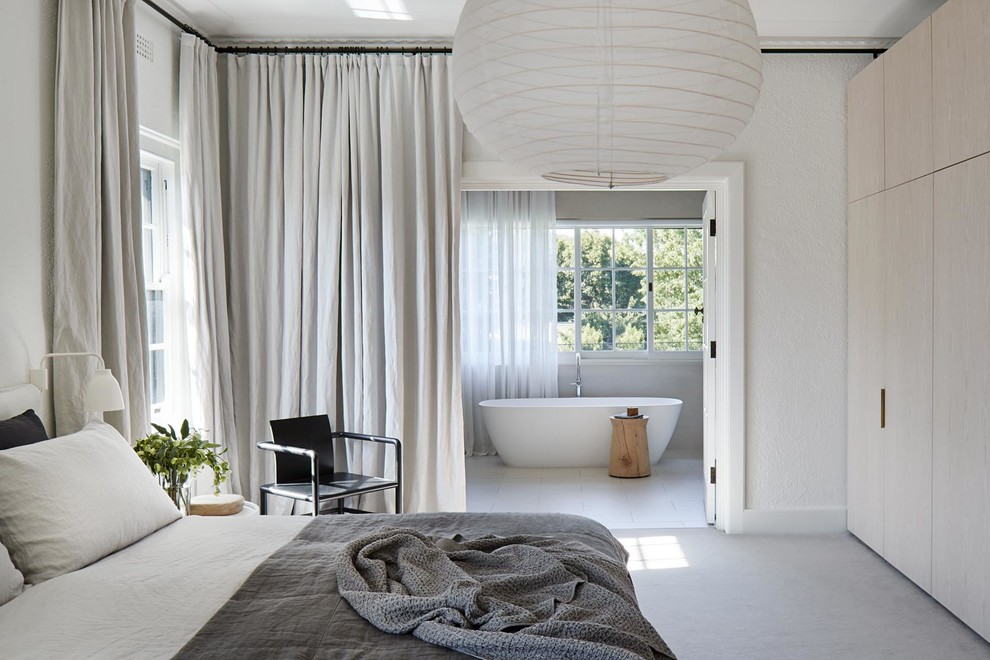 Contemporary master bedroom in Melbourne with white walls, no fireplace and grey floor.