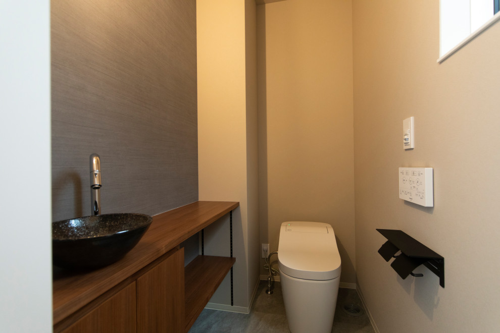 Exemple d'un WC et toilettes en bois brun avec un placard sans porte, un carrelage multicolore, un sol en vinyl, un sol gris, un plan de toilette marron, meuble-lavabo sur pied, un plafond en papier peint et du papier peint.