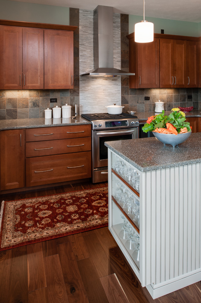 Example of a mid-sized transitional l-shaped medium tone wood floor open concept kitchen design with an undermount sink, shaker cabinets, medium tone wood cabinets, quartzite countertops, gray backsplash, stone tile backsplash, stainless steel appliances, blue walls and an island