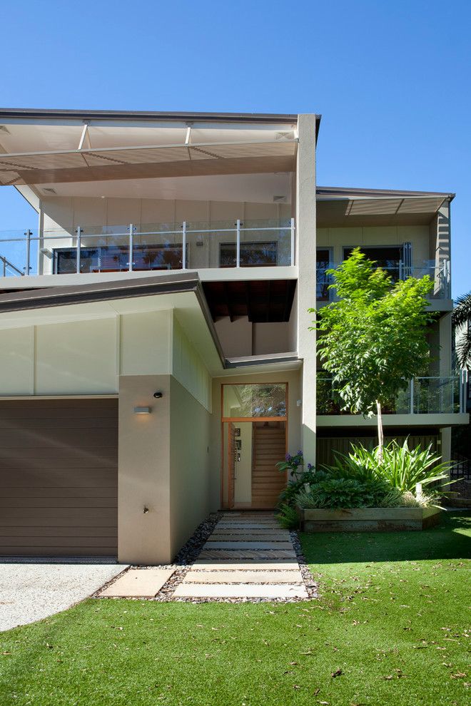 Inspiration for a large contemporary three-storey beige exterior in Brisbane with concrete fiberboard siding and a shed roof.