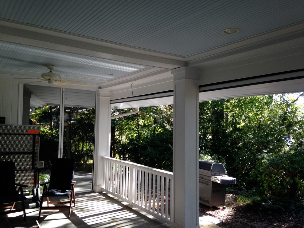 Large country backyard screened-in verandah in New York with natural stone pavers and a roof extension.