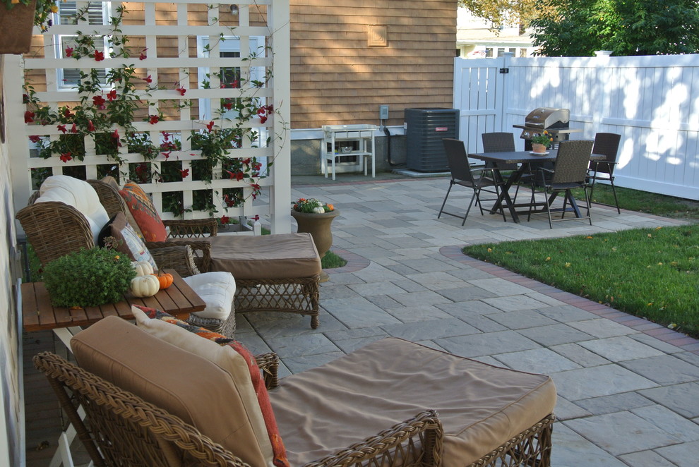 Design ideas for a small mediterranean backyard patio in Providence with concrete pavers and an awning.