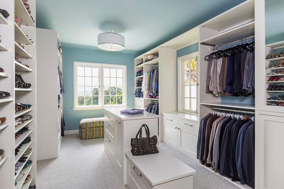 This is an example of a transitional gender-neutral walk-in wardrobe in San Francisco with white cabinets, carpet, shaker cabinets and grey floor.