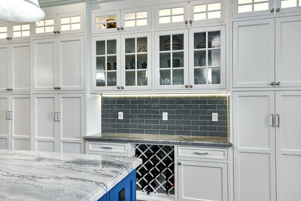 Idéer för ett stort klassiskt blå kök, med en trippel diskho, luckor med profilerade fronter, vita skåp, bänkskiva i kvartsit, blått stänkskydd, stänkskydd i keramik, integrerade vitvaror, klinkergolv i porslin, en köksö och grått golv