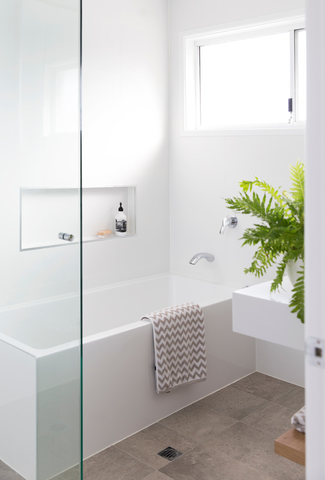 Design ideas for a small scandinavian bathroom in Gold Coast - Tweed with flat-panel cabinets, white cabinets, a corner tub, a corner shower, a one-piece toilet, white tile, ceramic tile, grey walls, ceramic floors, an integrated sink and engineered quartz benchtops.