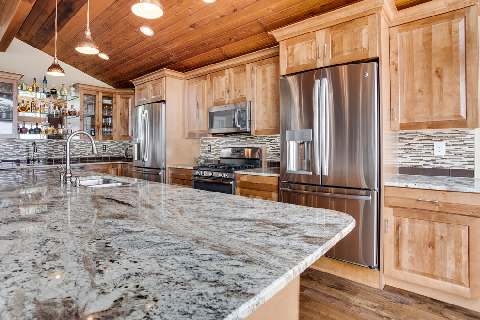 Large mountain style kitchen photo in DC Metro with an undermount sink, raised-panel cabinets, granite countertops, glass tile backsplash, stainless steel appliances and an island