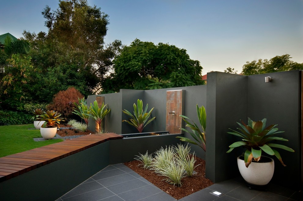 This is an example of a large contemporary backyard garden in Brisbane with a water feature.
