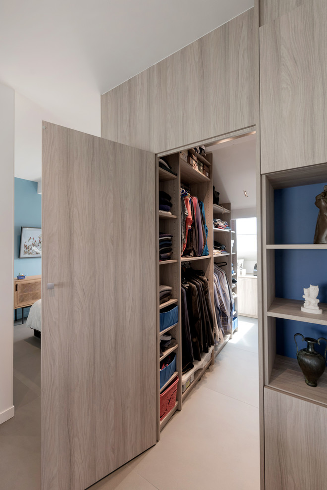Inspiration for a mid-sized contemporary gender-neutral walk-in wardrobe in Lyon with beaded inset cabinets, light wood cabinets, concrete floors and grey floor.