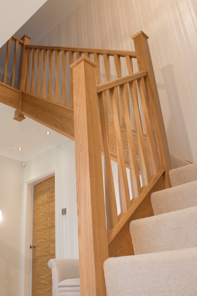 Design ideas for a contemporary carpeted l-shaped staircase in Cheshire with carpet risers and wood railing.