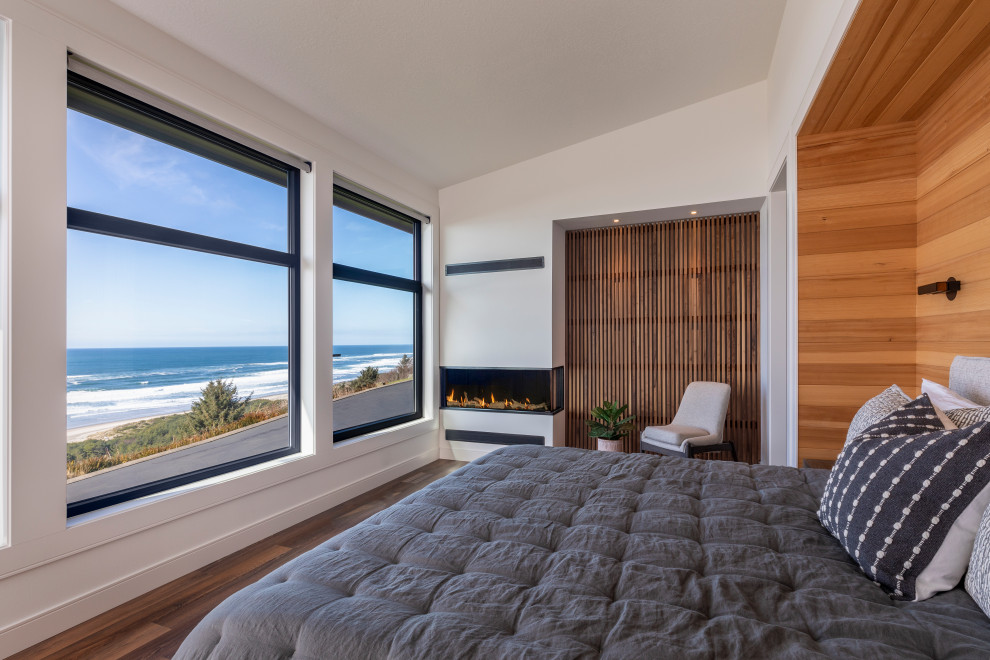 Modernes Schlafzimmer mit weißer Wandfarbe, dunklem Holzboden, Gaskamin, braunem Boden und Holzwänden in Portland