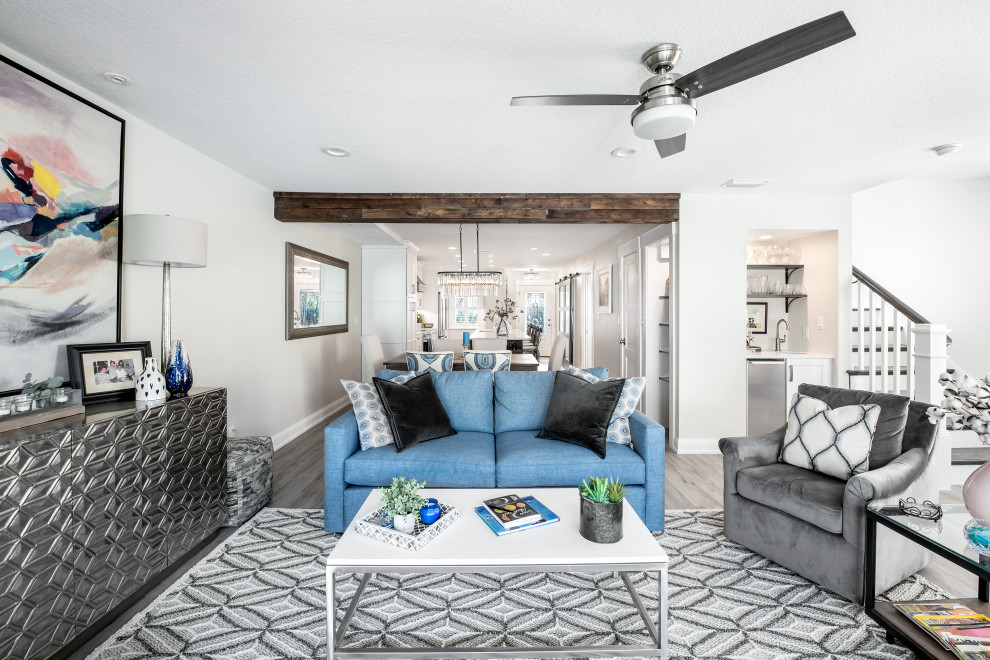 Photo of a mid-sized eclectic open concept family room in Tampa with grey walls, vinyl floors, a corner tv and brown floor.