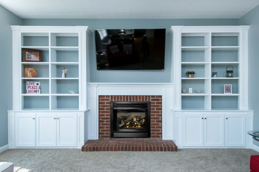 This is an example of a mid-sized traditional enclosed family room in Columbus with blue walls, carpet, a standard fireplace, a brick fireplace surround, a wall-mounted tv and grey floor.