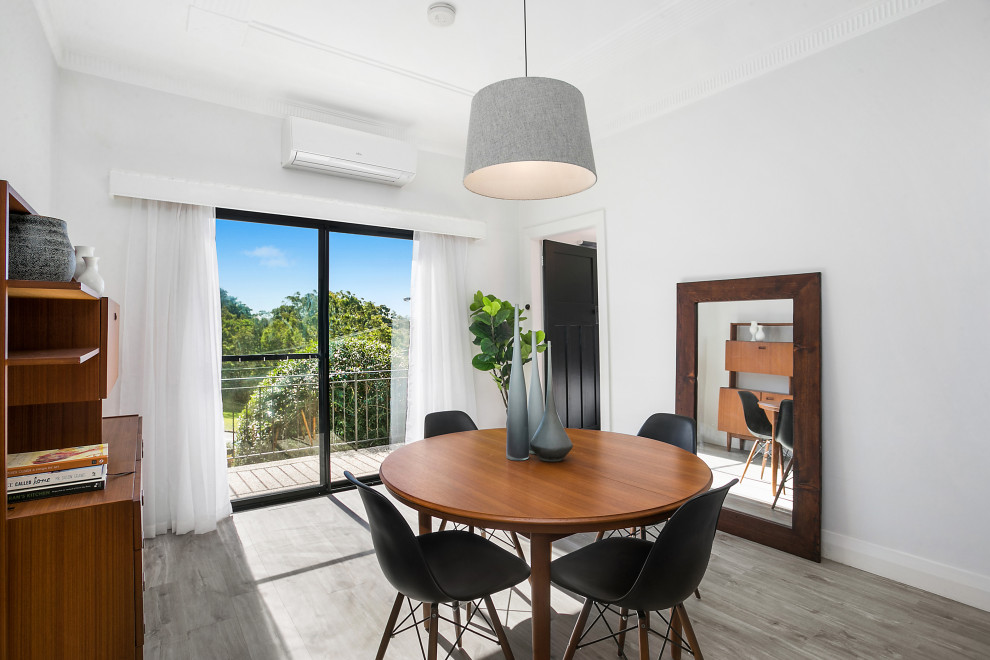 This is an example of a mid-sized contemporary kitchen/dining combo in Sydney with white walls, light hardwood floors and beige floor.