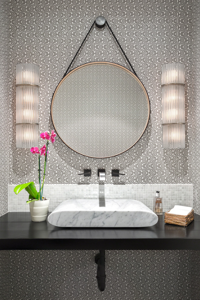 Photo of a contemporary powder room in New York with mosaic tile, grey walls, a vessel sink and black benchtops.