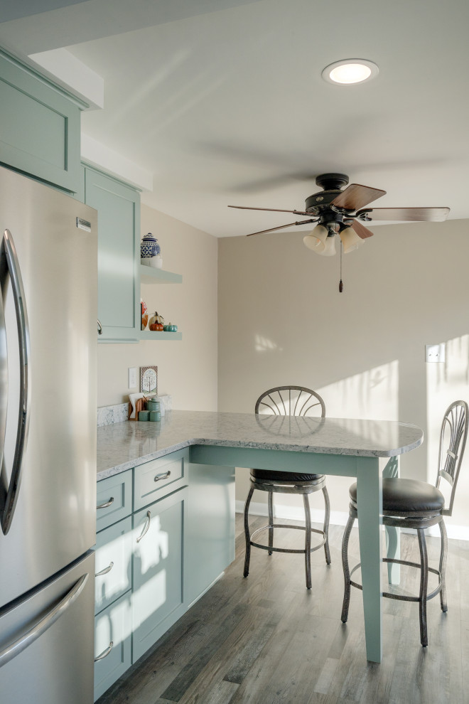 Inspiration for a small transitional l-shaped vinyl floor and brown floor enclosed kitchen remodel with an undermount sink, shaker cabinets, green cabinets, quartz countertops, stainless steel appliances, a peninsula and gray countertops