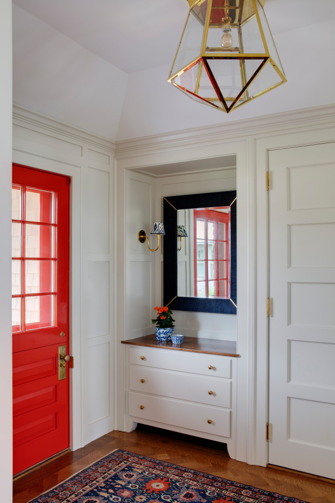 Immagine di un ingresso stile marinaro con pareti bianche, pavimento in legno massello medio, una porta singola, una porta rossa e soffitto a volta