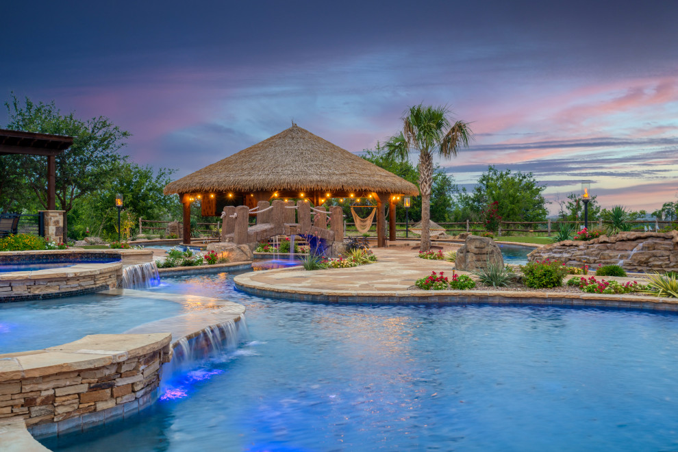 Inspiration for an expansive country backyard custom-shaped pool in Dallas with a water slide and natural stone pavers.