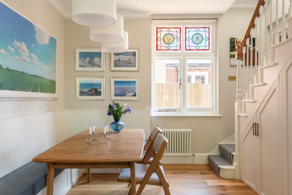 Design ideas for a medium sized traditional dining room in Kent with white walls, light hardwood flooring, beige floors, feature lighting and banquette seating.