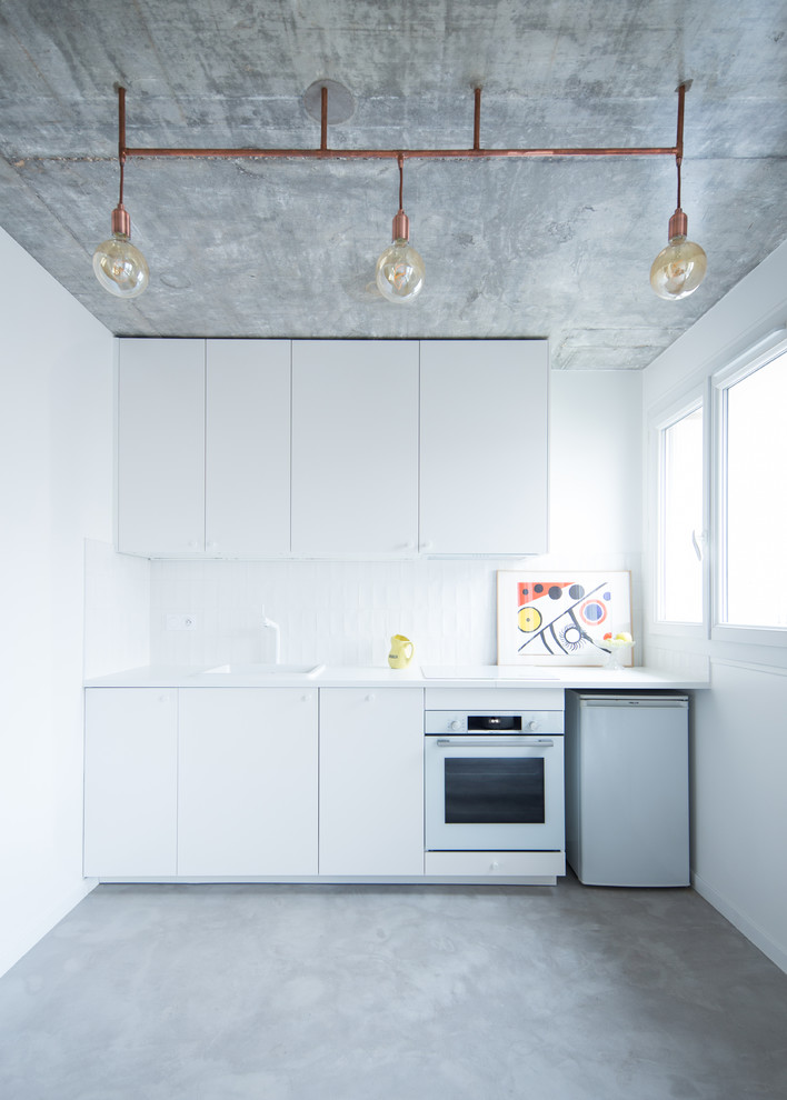 Design ideas for a small scandinavian single-wall eat-in kitchen in Paris with an integrated sink, beaded inset cabinets, white cabinets, quartzite benchtops, white splashback, stainless steel appliances, concrete floors, no island, grey floor and white benchtop.