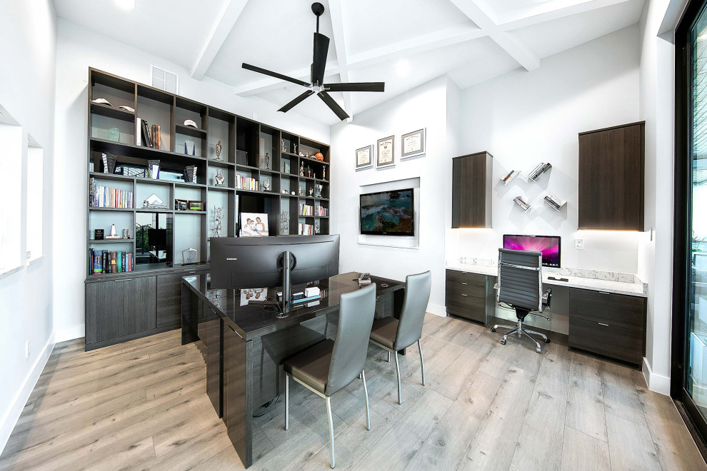 Inspiration for a large contemporary study room in Austin with white walls, a built-in desk and grey floor.