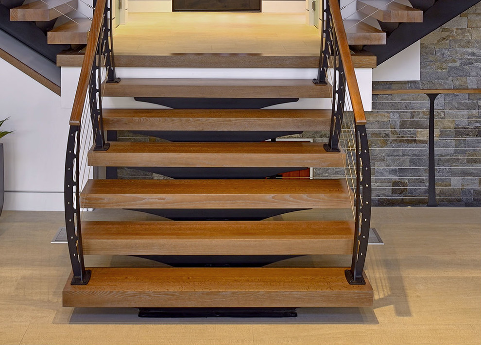This is an example of a modern wood floating staircase in New York with open risers and metal railing.