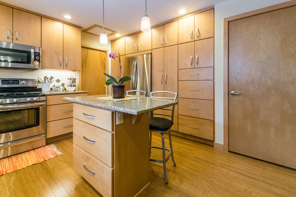 Mid-sized midcentury u-shaped separate kitchen in Chicago with an undermount sink, flat-panel cabinets, light wood cabinets, granite benchtops, white splashback, ceramic splashback, stainless steel appliances, bamboo floors and with island.